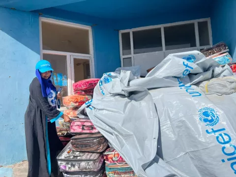 On 8 October 2023 a UNICEF child protection specialist distributes blankets to earthquake affected children in western Herat in Afghanistan.