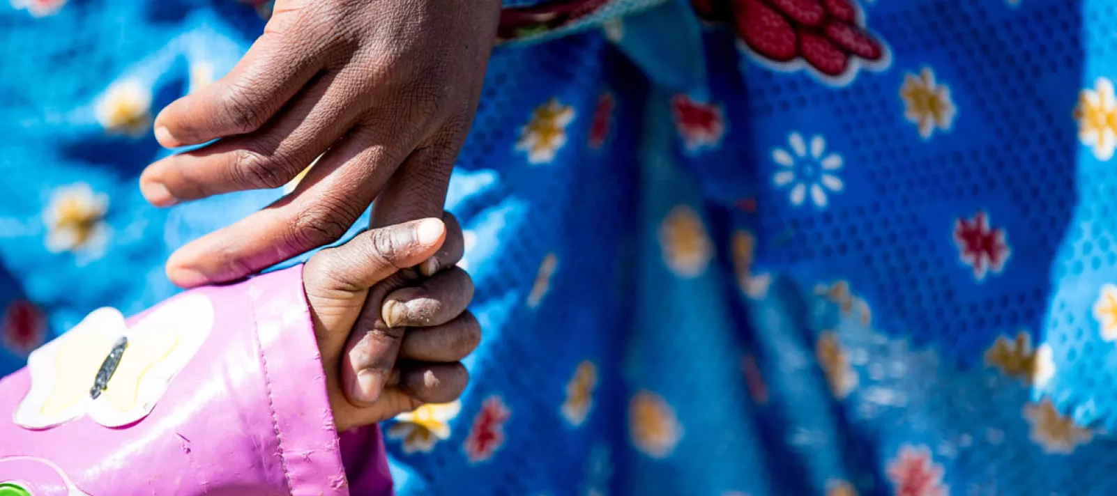 A mother and a child hold hands. UNICEF/Angola/2016/Karin Schermbrucker