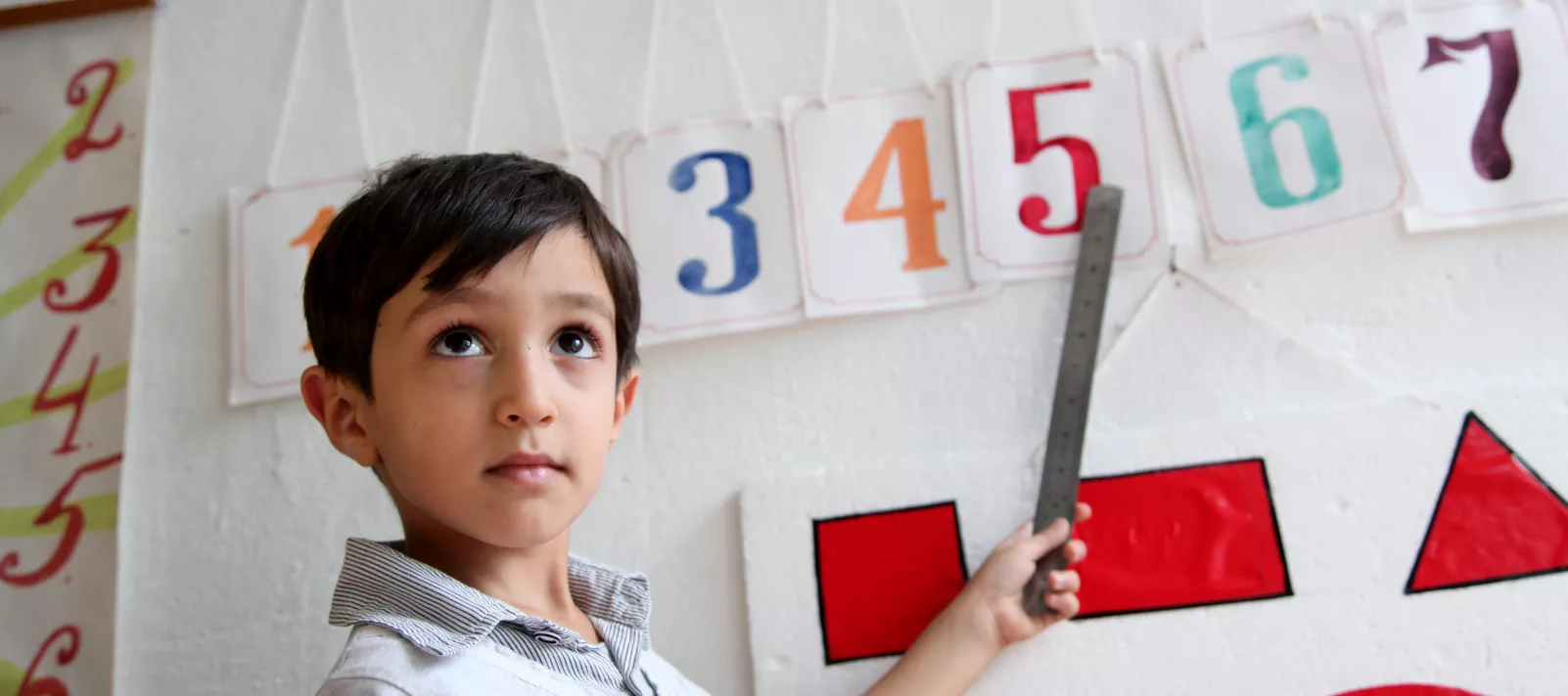 A boy learns how to read numbers.