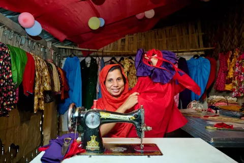 Sabina, 26, sews a dress at her home in Teknaf, Cox’s Bazar. She opened her own tailoring business after receiving training through the Cash Plus Project.
