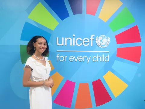 girl stands beside UNICEF sign