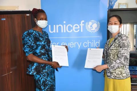 UNICEF Deputy Rep and Rotary Club of Banjul President hold up MOU after signing