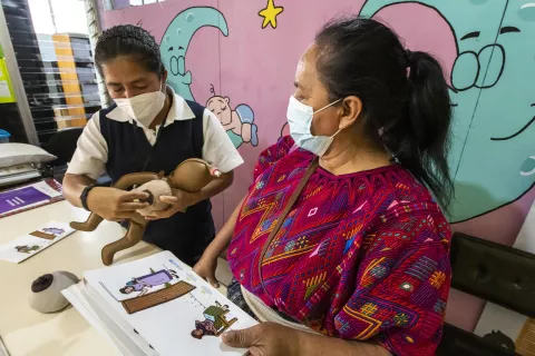 La enfermera Micaela repasa con la comadrona Juana parte del material didáctico relacionado con la lactancia materna.