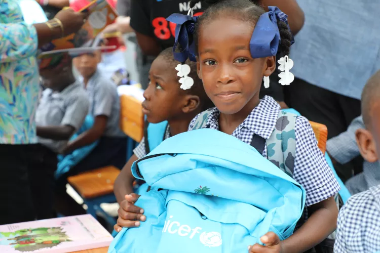 une élève de l'École nationale de Maingrette contente de recevoir son kit scolaire, Aquin, Haïti.
