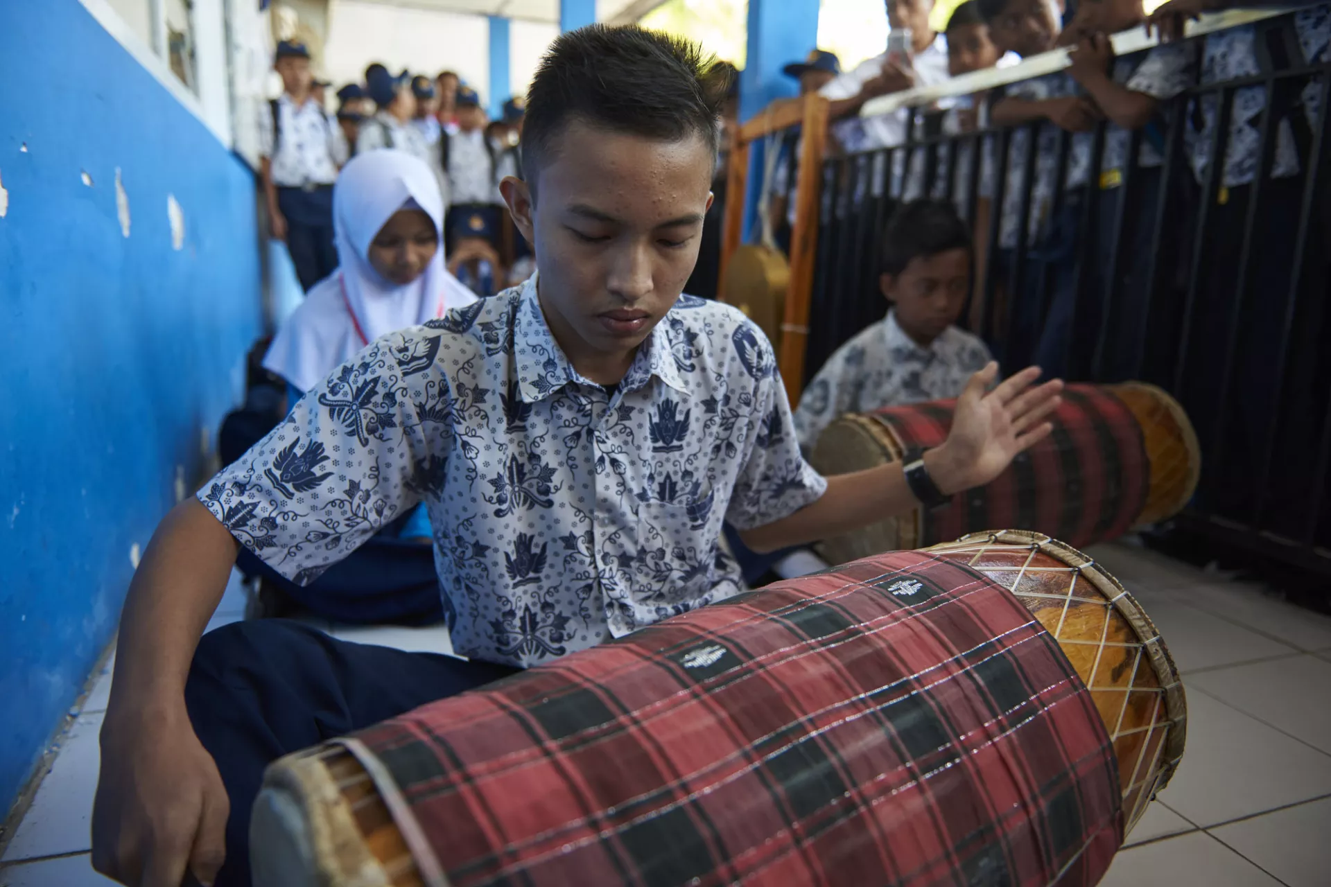 A young boy playing an instrument in school.