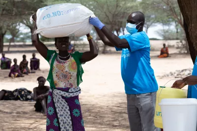 A woman receives family relief kits in Naotin village, Turkana County. 
