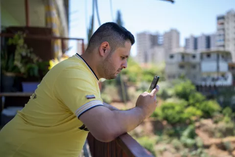 Mohammad, 27 years, looking at his phone