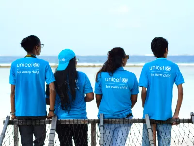 Four adolescents in UNICEF shirts participate in a photography project.