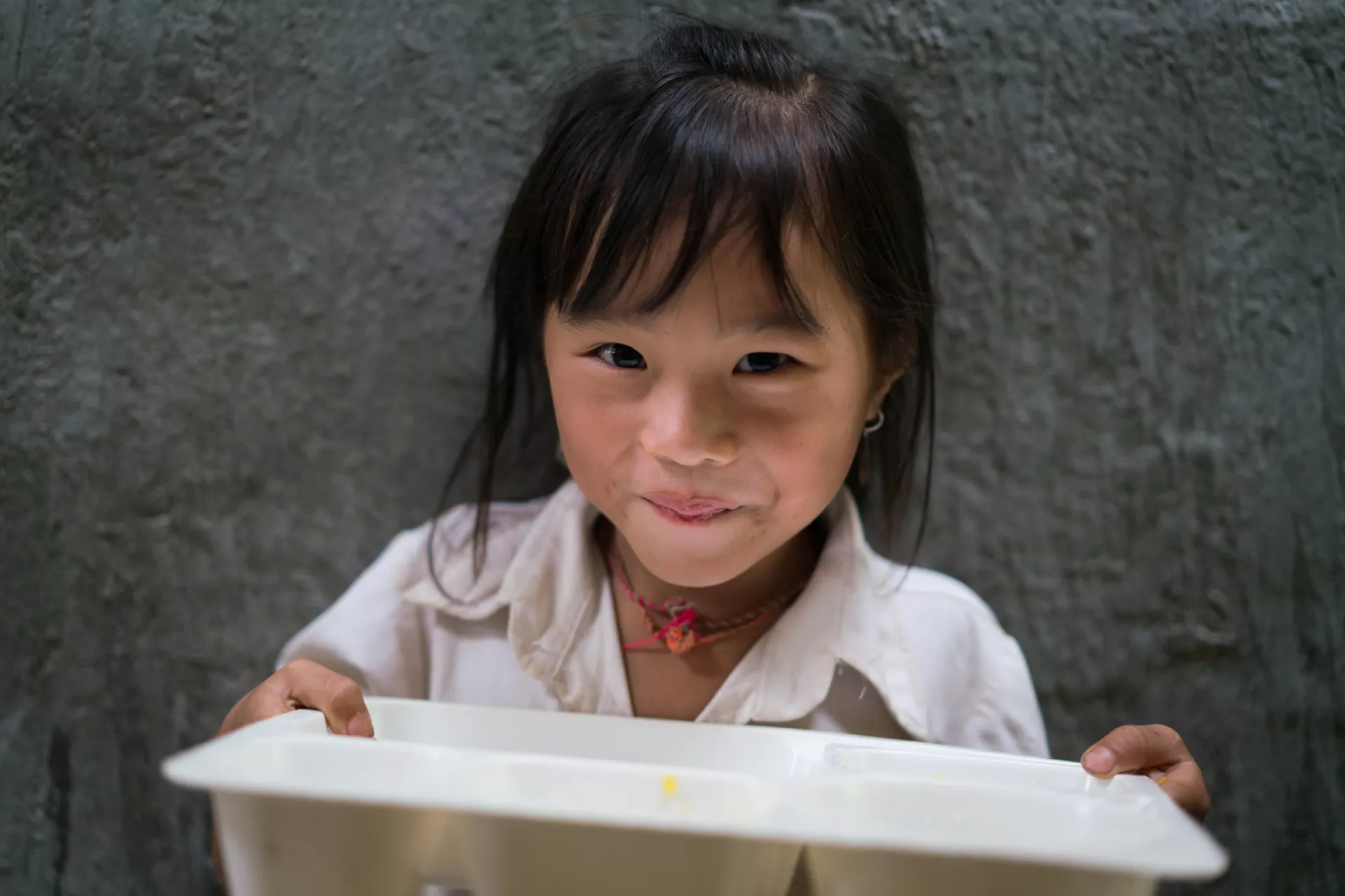 A young girl in Vietnam holds her lunch tray at her primary school.