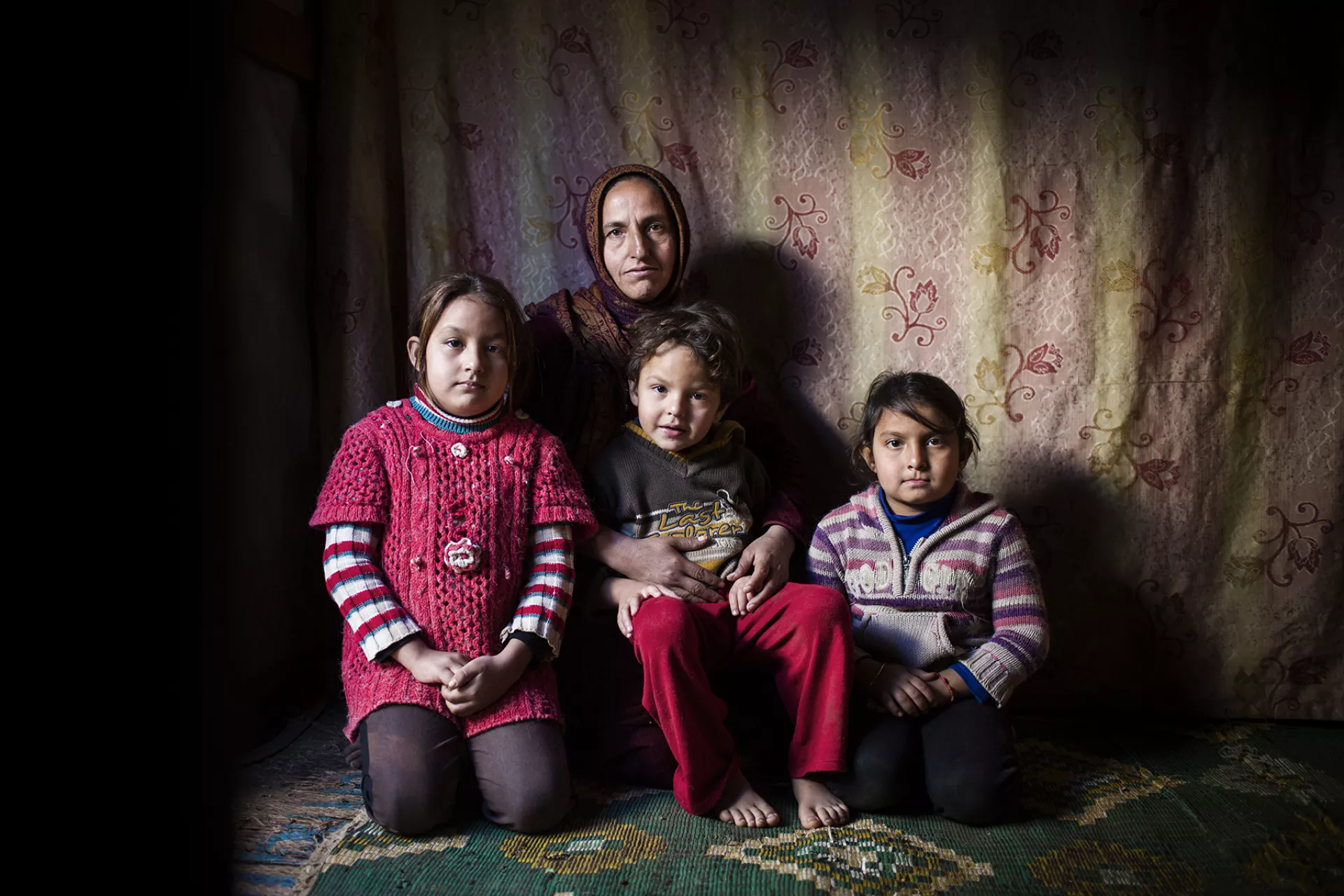 A woman sits with three children, Lebanon