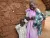 A mother stands with her son and new baby outside their home, South Sudan