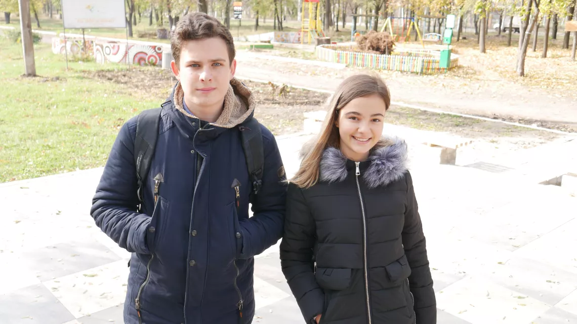 Olexandra and Danylo stand over the outdoor chessboard