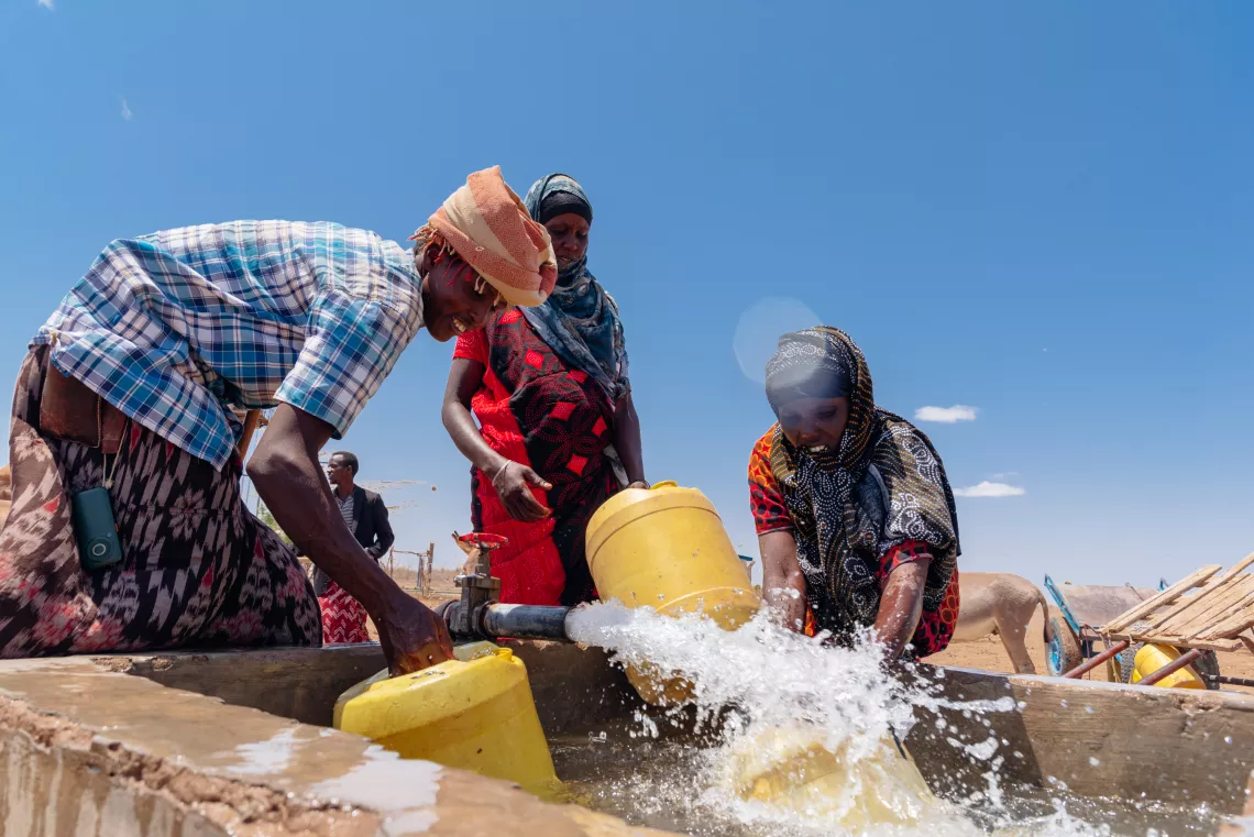 肯尼亚。在肯尼亚加里萨，人们在由联合国儿童基金会安装的太阳能水泵供电的供水点取水。