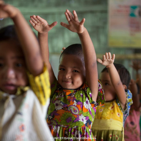 Unos niños de Bangladesh alzan sus brazos mientras practican un baile