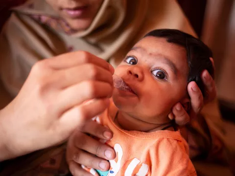 A child receives a dose of the rotavirus vaccine