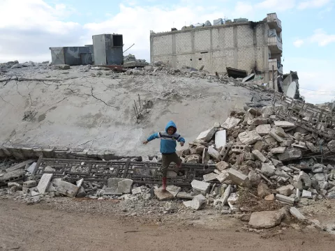 A child walks on a collapsed building