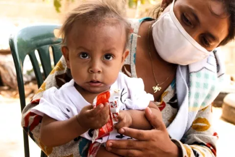 Jesús Gonzalez, 1, looks at the camera while he eats a ready-to-use therapeutic food (RUFT) during a nutrition screening day in Ciudad Bendita neighborhood, Zulia, Venezuela.