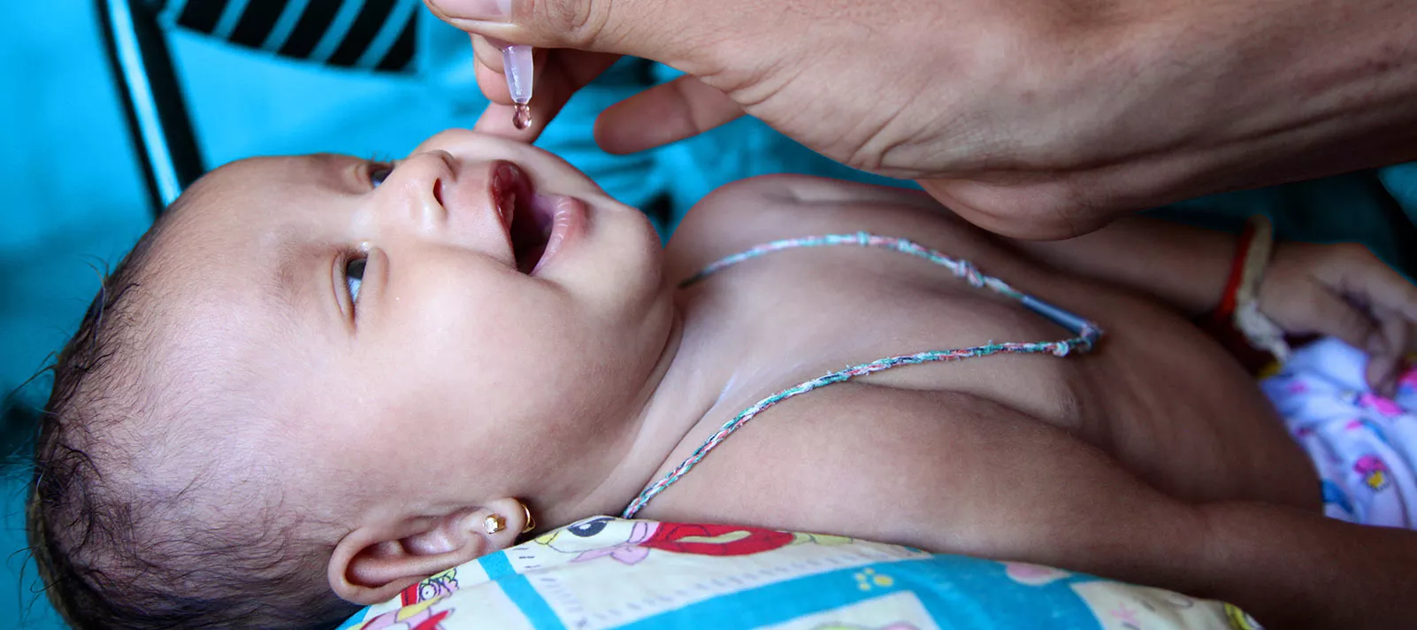 A baby is administered an oral vaccine during an immunization session at the health centre in the village of Preak Krabao, Kang Meas District, Cambodia, June 2015.