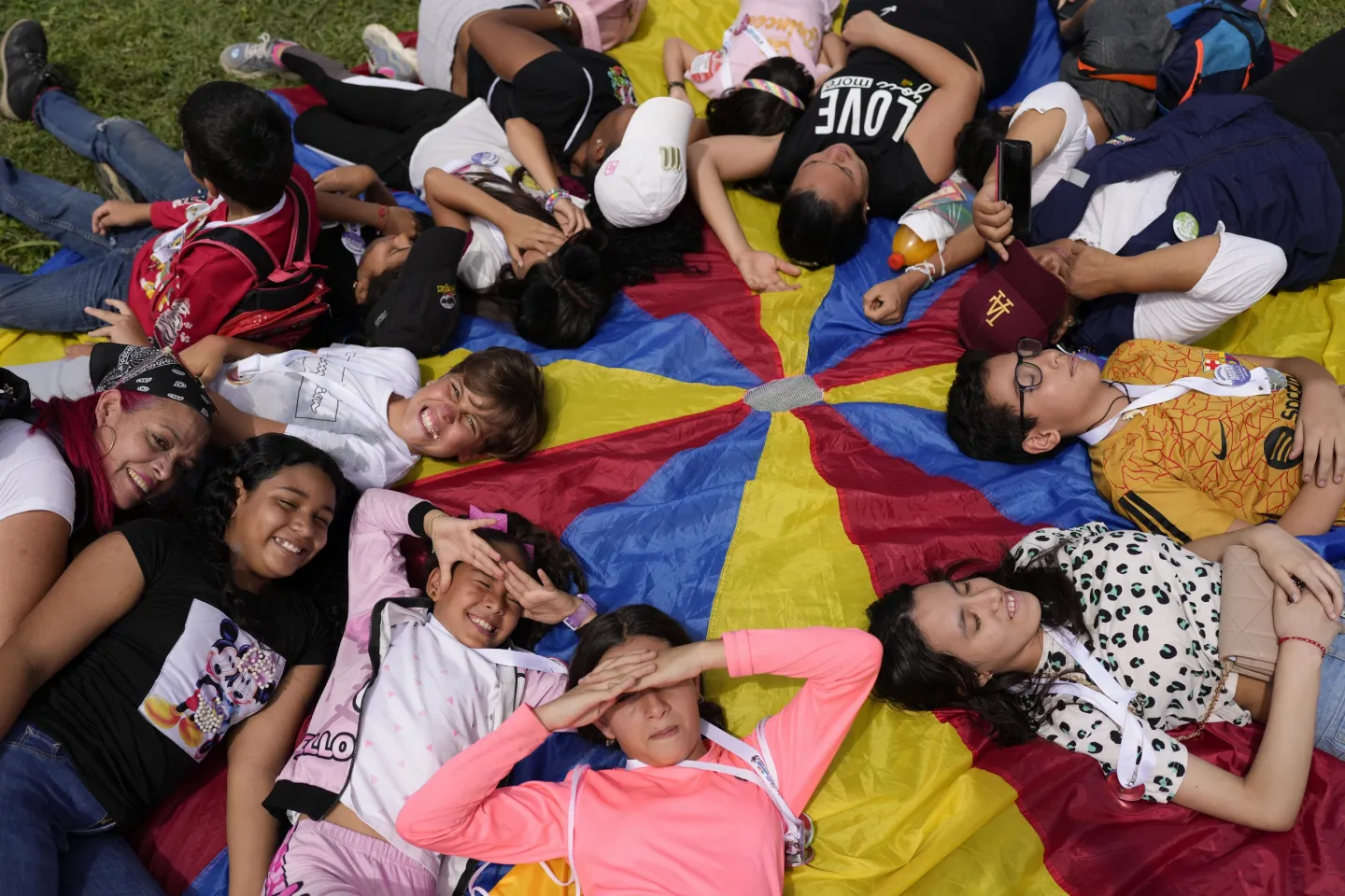 Young people lay on their backs in a circle.