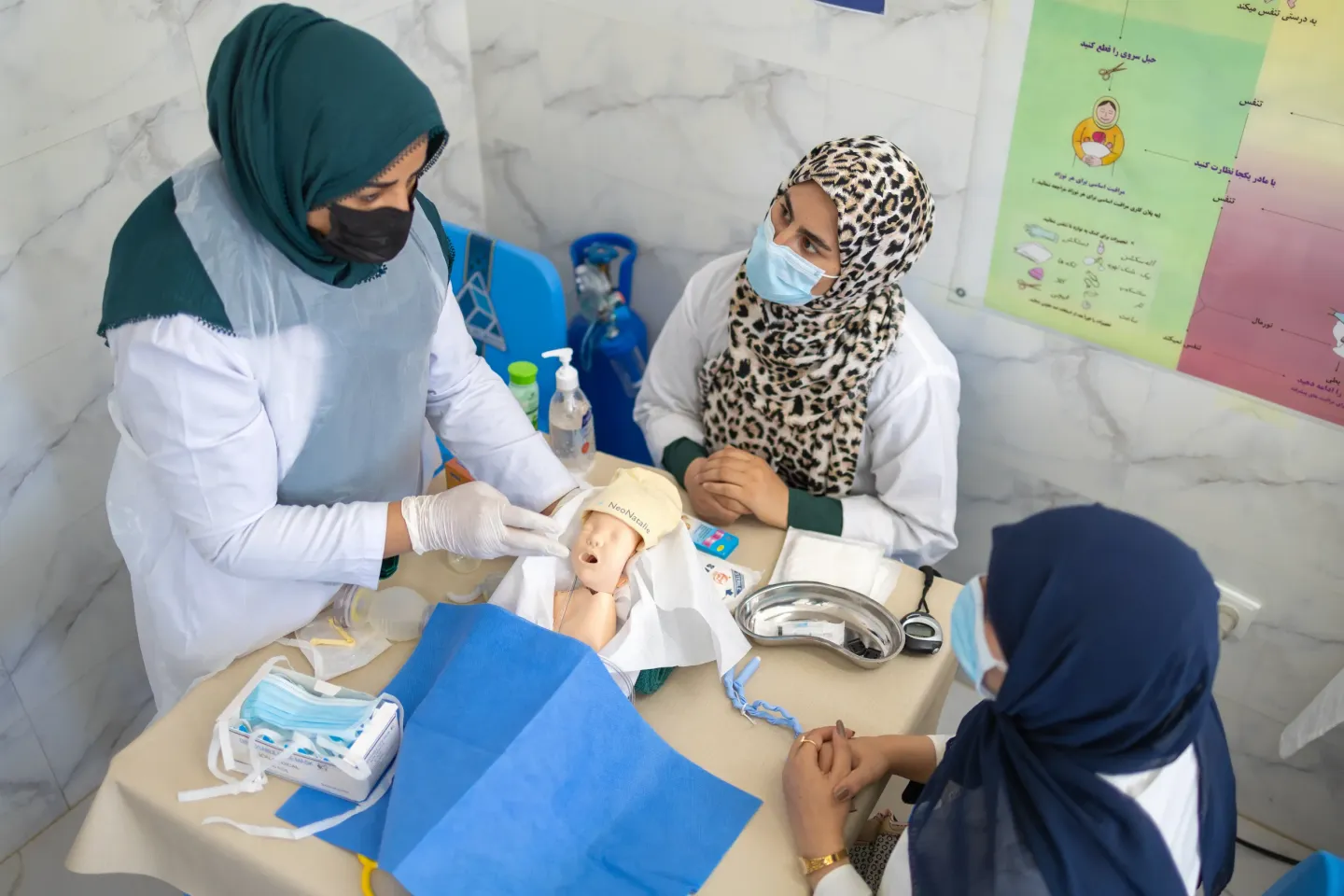 In the Skills Lab at Guzara Hospital, Suhaila midwife conducts a practical training session for two newly trained colleagues.