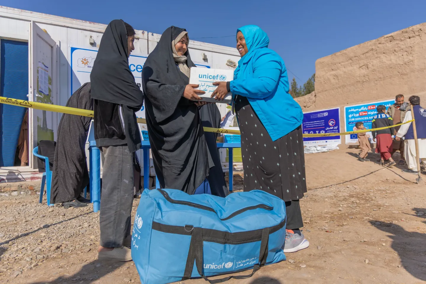 UNICEF Chief of Field Office Fathia Omar Hasan hands a hygiene kit to 11-year-old Asena and her mother, who recently returned from Iran, as part of UNICEF winterization support for returnee families.