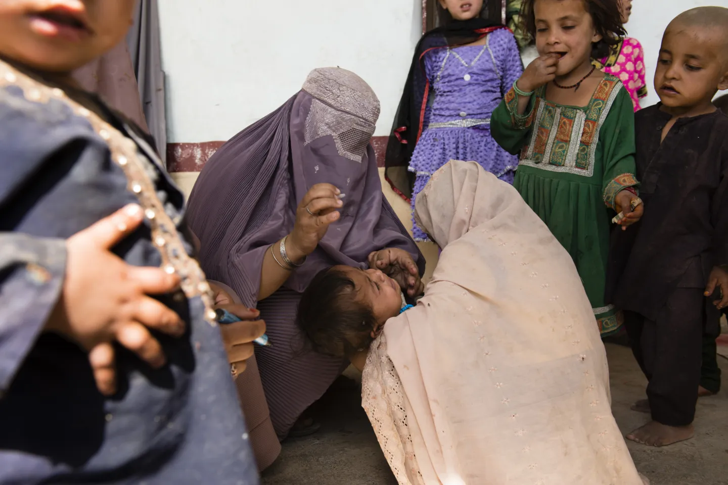 A woman giving polio vaccine to a child 