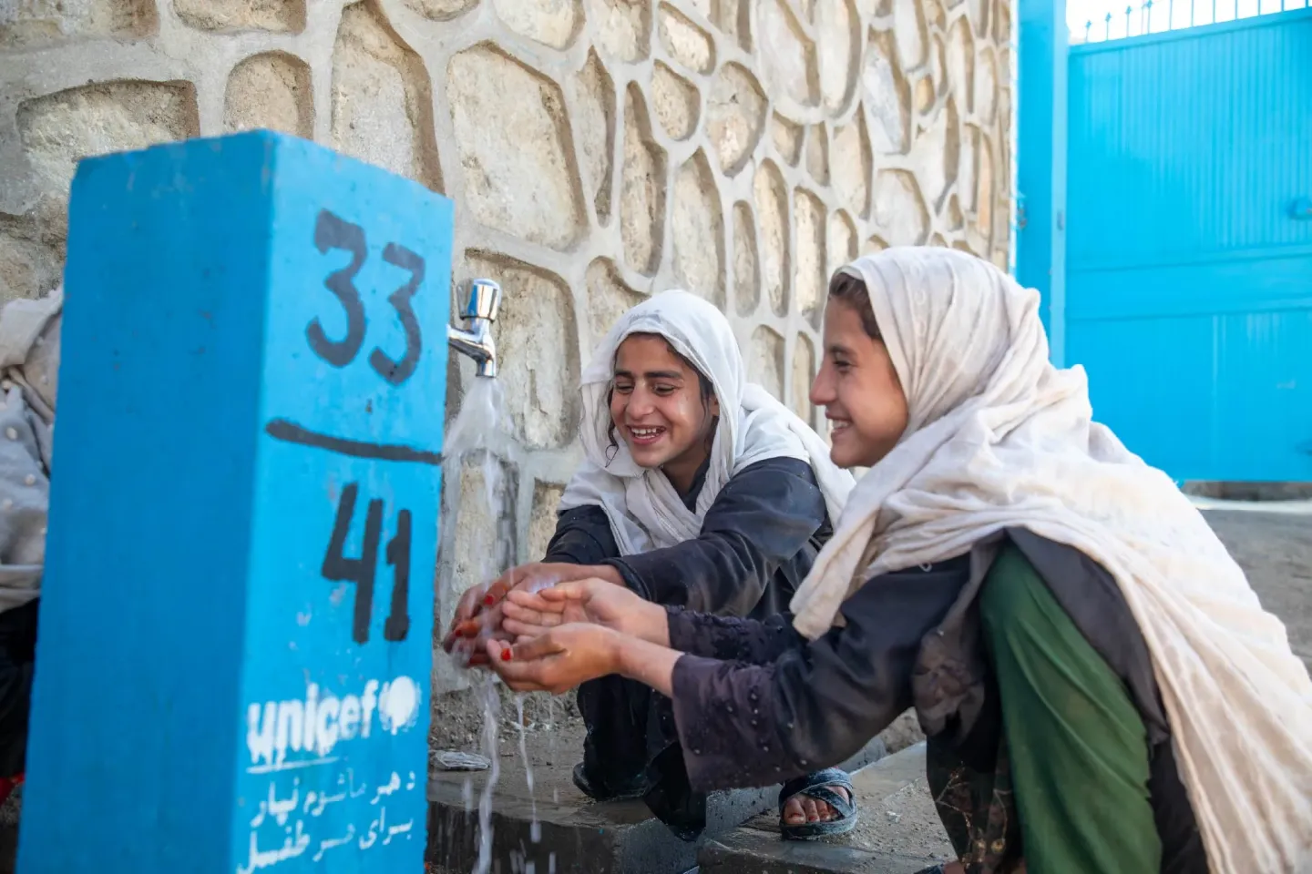 Alia, a 13-year-old fourth-grade student, with her friends, happy to receive clean, safe water at Want High School, Nuristan Province, Afghanistan.