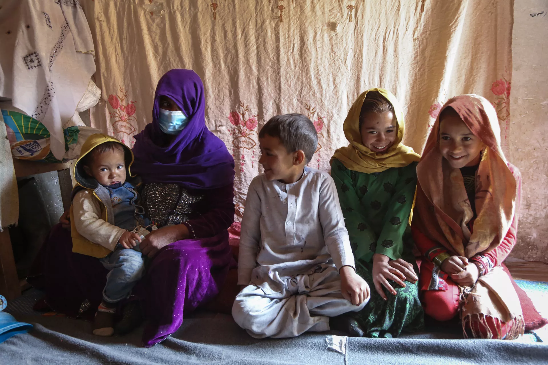 Kamina sits with her 5 children inside their family home at Qala-e Abdul Ali informal settlement for internally displaced persons in Kabul, Afghanistan.