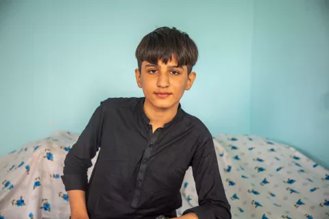 In December 2023, 12-year-old Matiullah sits in a dormitory at the UNICEF-supported drop-in center for unaccompanied and separated children in Nangarhar Province, Afghanistan at the Torkham border.