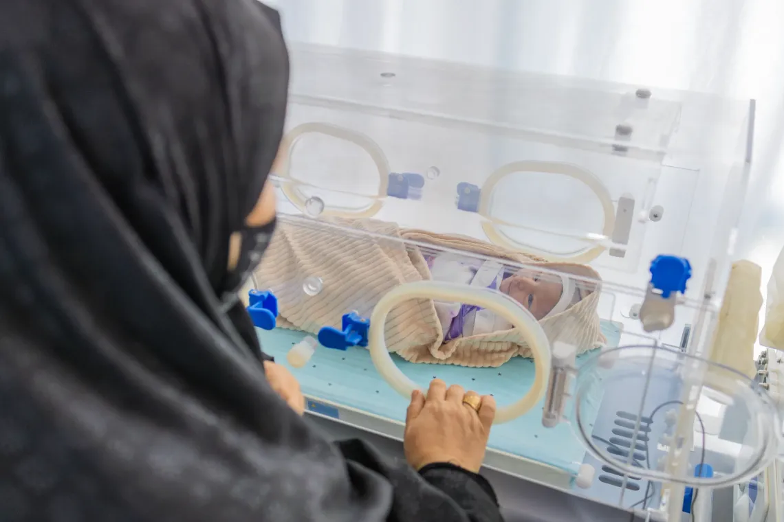 Nilofar&rsquo;s grandmother, Fatima, stands beside the newborn radiant warmer while observing the newborn during routine postnatal care.