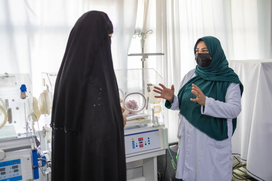 Suhaila explains to Mah Jan, the newborn's aunt, how to care for the baby at home while the newborn remains under observation in radiant warmer in Herat Afghanistan.