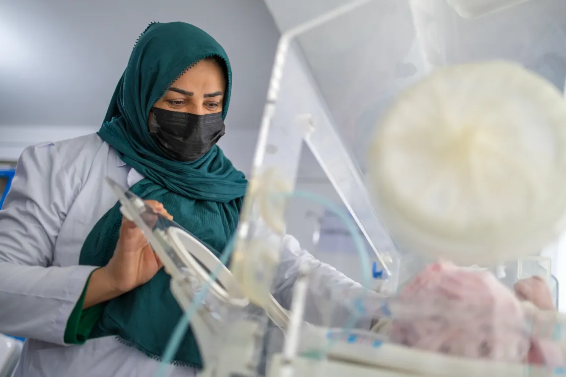 The newborn rests in an ADB- and UNICEF-supported radiant warmer while a midwife examines him, monitors his vital signs, and ensures he is healthy and stable following birth.