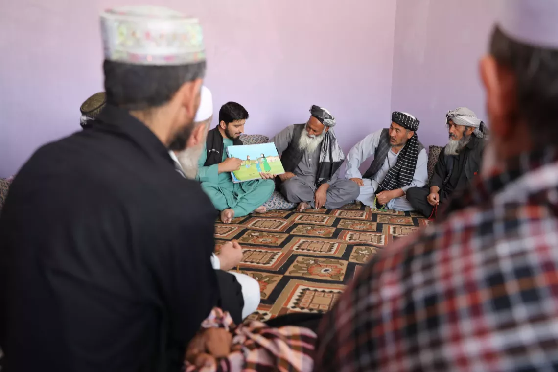 Tabesh, a polio survivor and social mobilizer provides information relating polio to some parents during the NID campaign of April, 2025 in Dehdadi District of Balkh. 