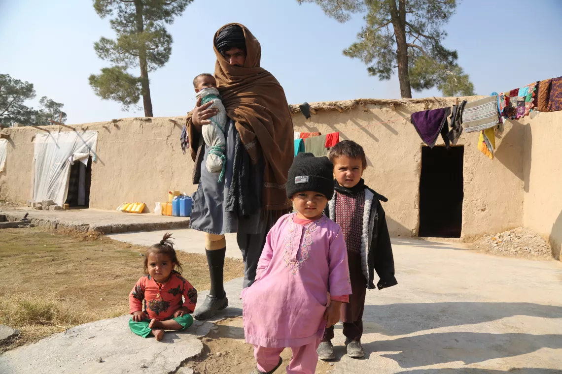 Surrounded by his three other children, Safa&rsquo;s father holds her outside their family home in Kandahar. Safa is suffering from severe acute malnutrition and receiving treatment from the UNICEF-supported Mirza Mohammad Khan Comprehensive Healthcare Centre. 