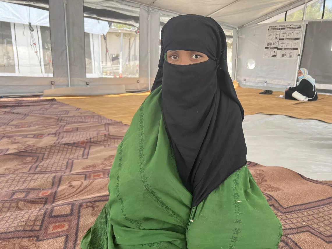On 10 October 2023 in western Afghanistan, Bibi Gul, 20, sits inside a temporary shelter at the UNICEF-supported transit centre in Herat city, where she temporary relocated after the earthquake destroyed her home.