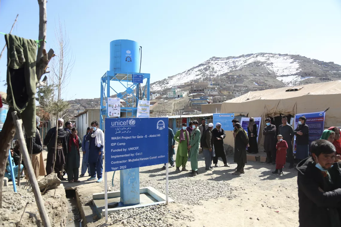 A wide view of the entrance to Qala-e Abdul Ali informal settlement for internally displaced persons in Kabul, Afghanistan is home to 271 people from 54 families. Over half of these residents are children.  In March 2022, UNICEF completed construction of a new water system inside the settlement with funding from USAID Bureau of Humanitarian Affairs. Now every family has convenient access to safe water right outside their homes.