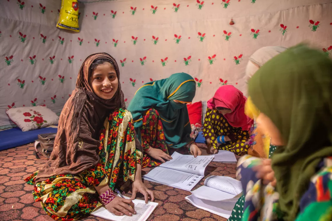 On 28 November 2023, in Parun district, Nuristan province, Afghanistan, Farzana studies her lessons at home, surrounded by her five sisters. With cash assistance from UNICEF, their mother, Saeed Khanum, can afford their continued education and school supplies.