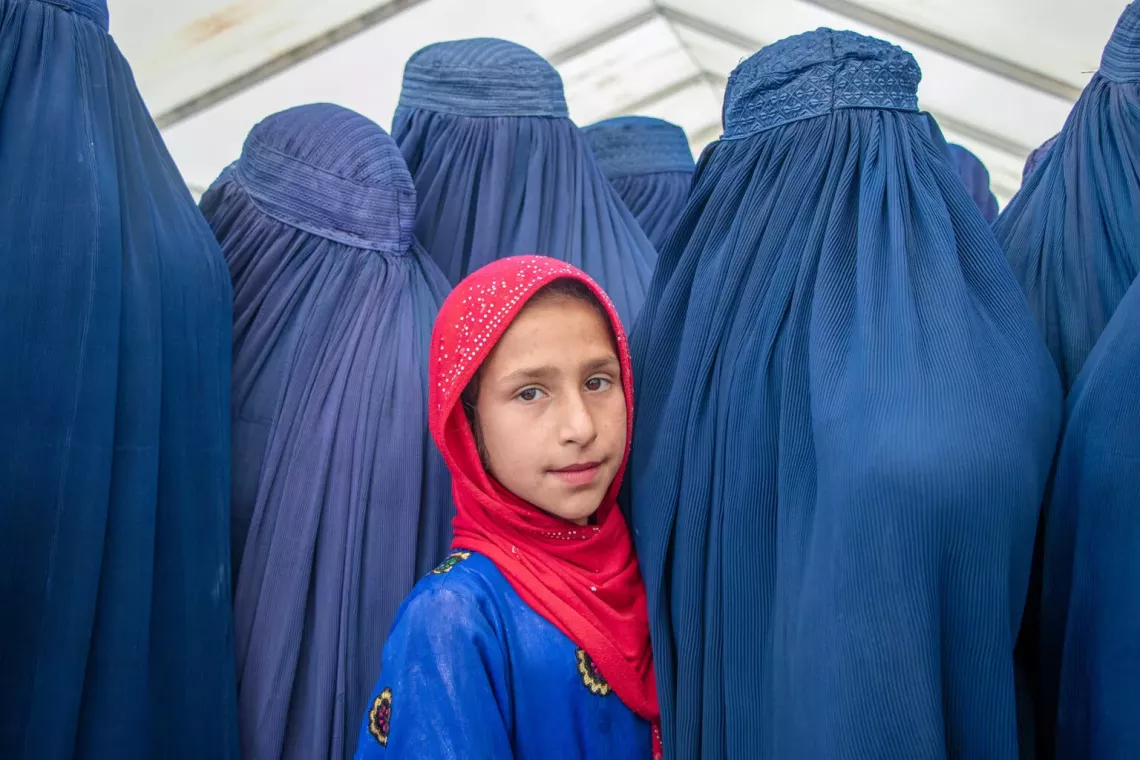 On 18 May 2024, 10-year-old Rana stands with her mother and other women to receive emergency cash assistance distributed by UNICEF following recent flash floods in Baghlan province, Afghanistan. &nbsp;These families receive a one-time cash distribution of $312 to help provide for their basic needs after the emergency. 