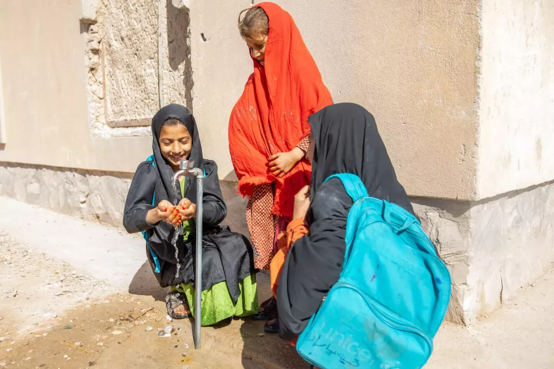 11-year-old Rohnama is washing her hands from the new water tap which brings clean drinking water to her school through a piped water system. 