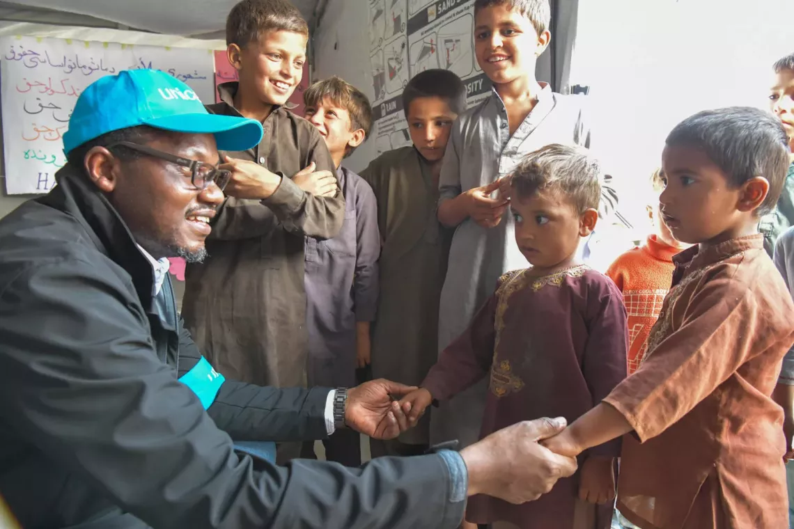On 20 April 2025, at Afghanistan's eastern Torkham border with Pakistan, Tajudeen Oyewale, UNICEF Representative, meets young boys at a UNICEF-supported child-friendly space in Omari Camp near the border, which supports returning families as they wait for relocation within Afghanistan. In the first two weeks of April, nearly 5,500 children at Torkham border attended UNICEF-supported child-friendly spaces and received psychosocial support services at the border zero-point and reception center.