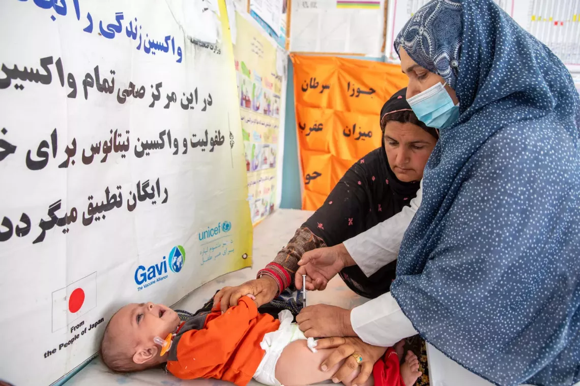 On 14th of April 2025, Karima Azimi is vaccinating 3-month-old Matiullah. she has been working as fixed vaccinator at Rawashan health facility in Injil district of western Herat province. On average, she is vaccinating 50-55 children on daily basis.