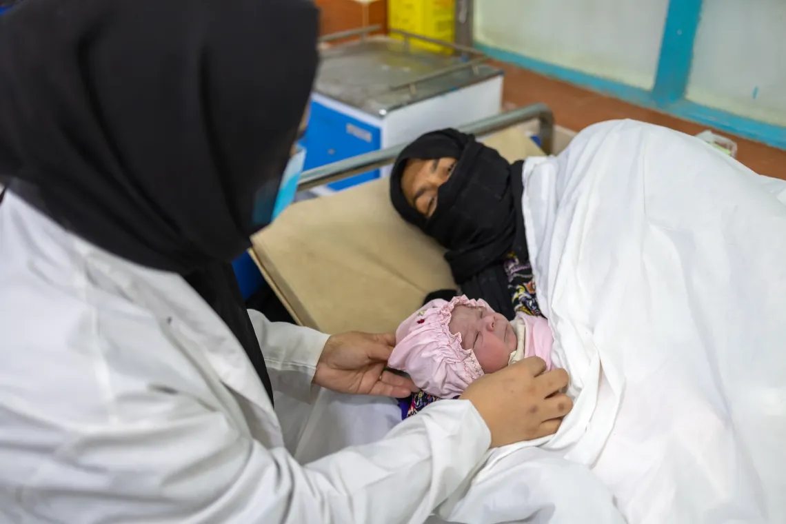 Karima, a midwife, counsels Azita on caring for the newborn, emphasizing exclusive breastfeeding, proper nutrition for the mother and hygiene practices, Herat, Afghanistan