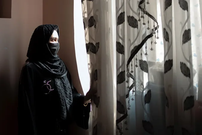 Sahar*, 17, stands in front of a window at her home. She was a Grade 10 student when secondary schools for girls were suspended.