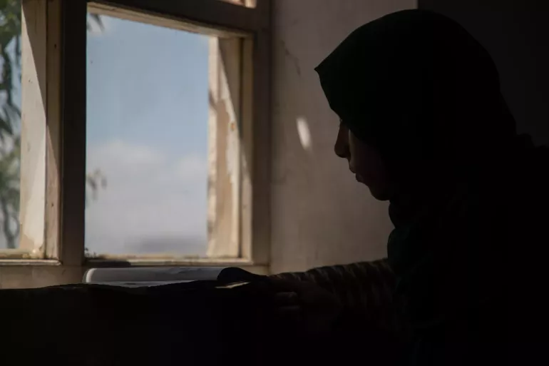 Adolescent girl looks out of window