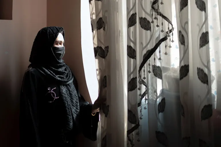 Sahar*, 17, stands in front of a window at her home. She was a Grade 10 student when secondary schools for girls were suspended.