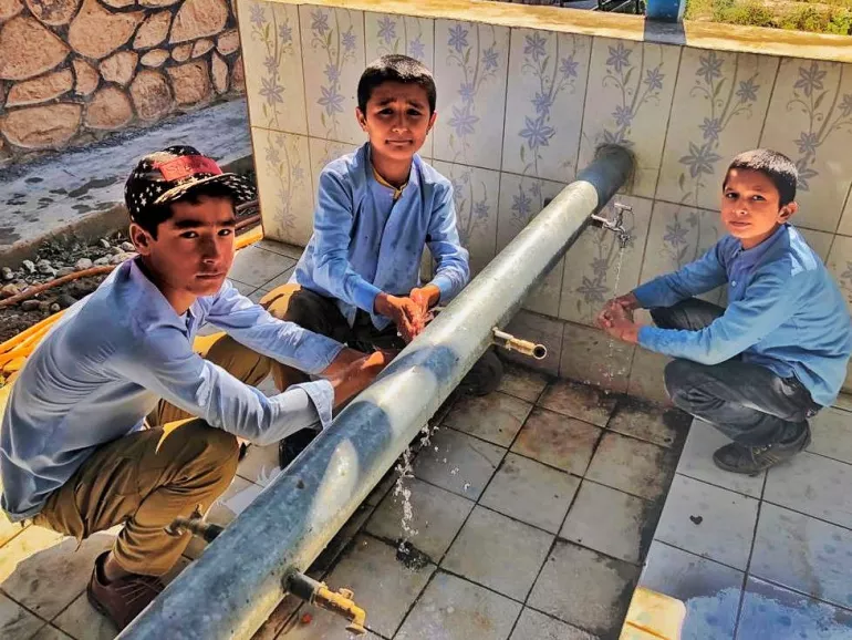 Three boys washing their hands