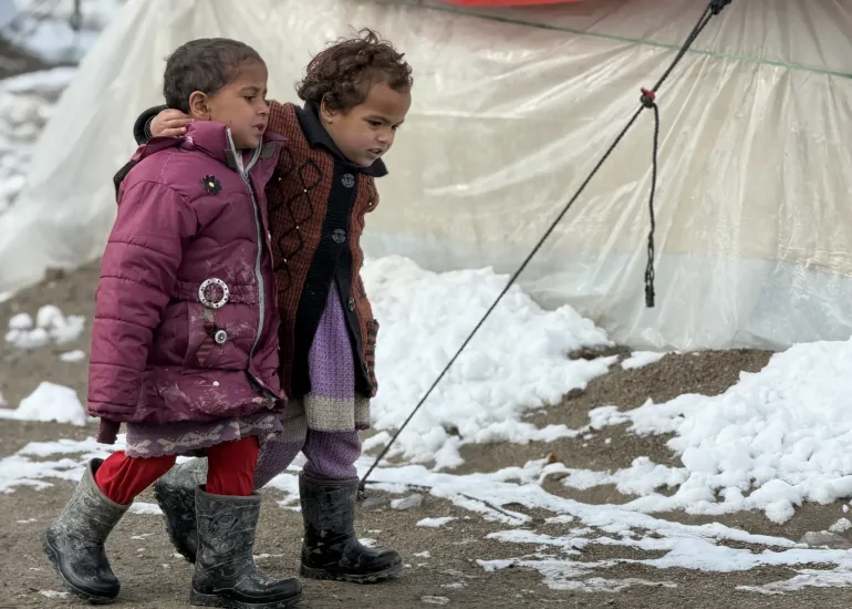 Children in north east Afghanistan walk in the snow
