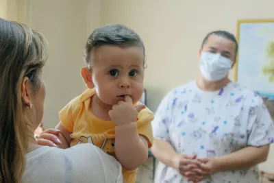 Nje beb i vogel qe mban gishtin ne goje
