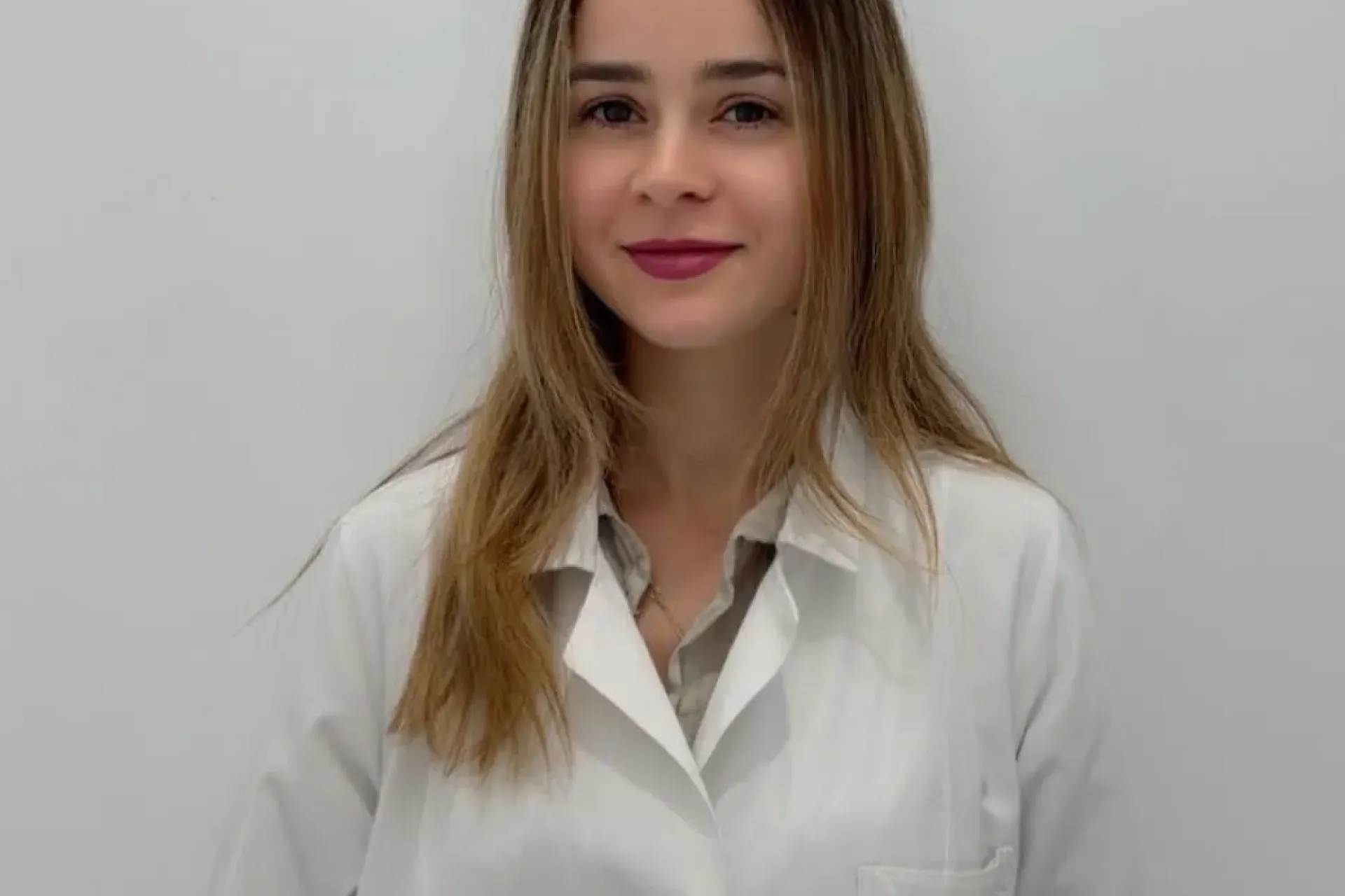 Nurse in uniform posing in front of a white wall