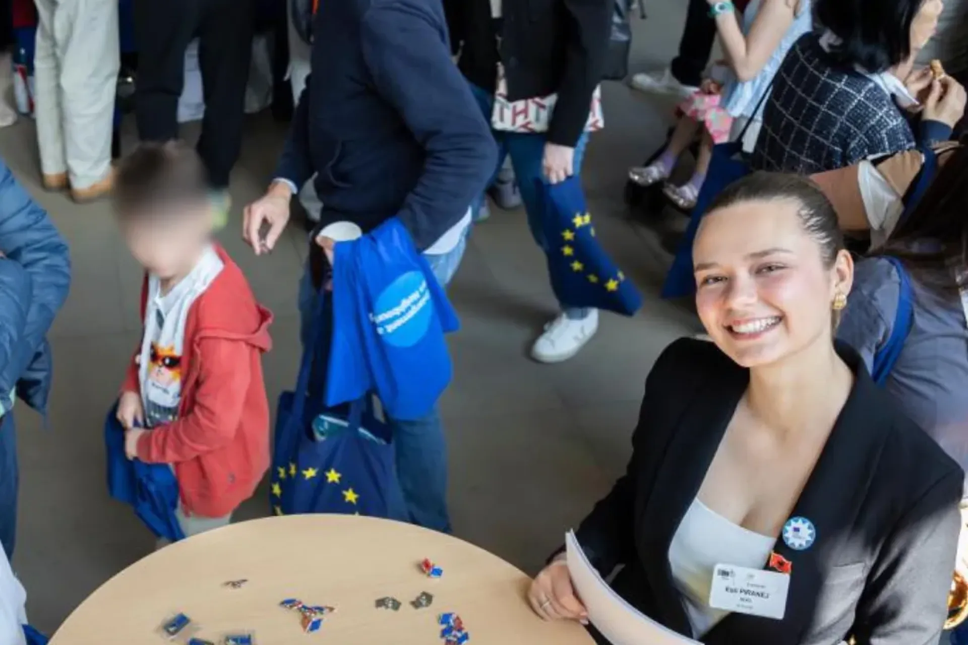 girl smiling in a conference surrounded by people in the background